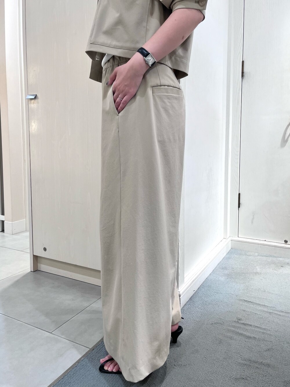 ベージュ系のブルゾン、ベージュ系のその他パンツ、ホワイト系のタンクトップを着用したレディースの春コーディネートの7枚目の写真