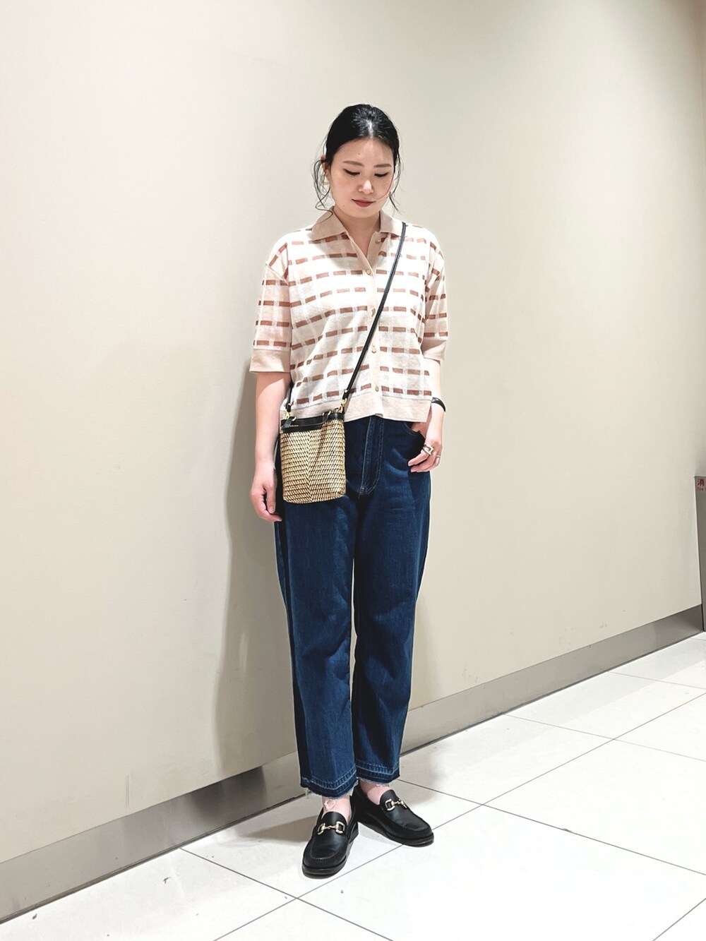 ベージュ系のニット/セーター、ブルー系のデニムパンツを着用したレディースの春コーディネートの2枚目の写真