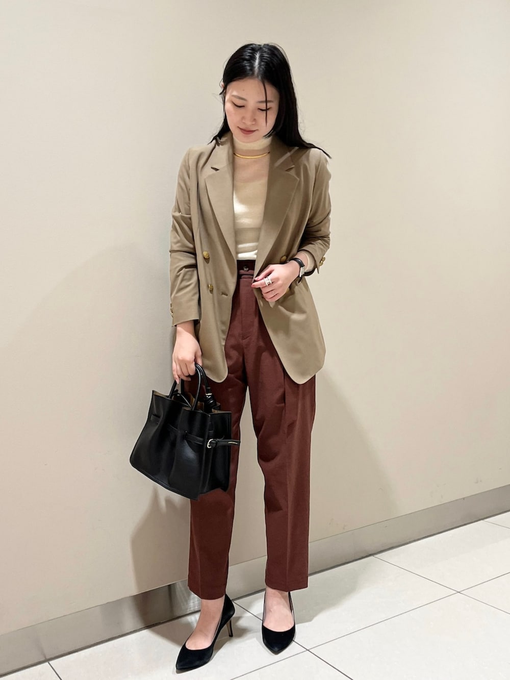 イエロー系のテーラードジャケット、ホワイト系のニット/セーター、レッド系のスラックスを着用したレディースの夏コーディネートの3枚目の写真