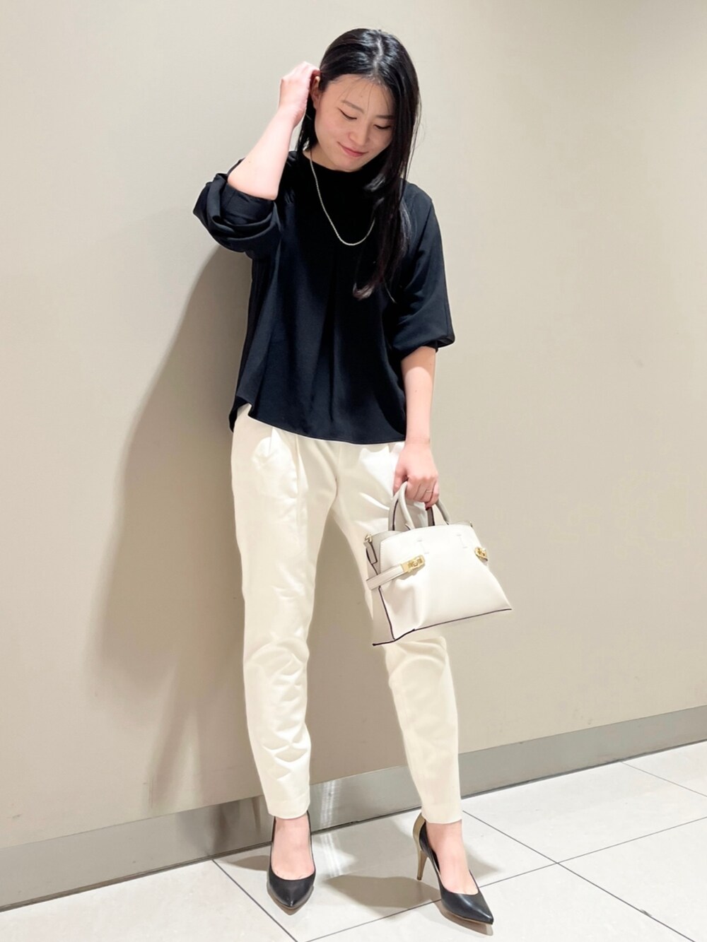 ブラック系のシャツ/ブラウス、ホワイト系のスラックス、ホワイト系のショルダーバッグを着用したレディースの冬コーディネートの2枚目の写真