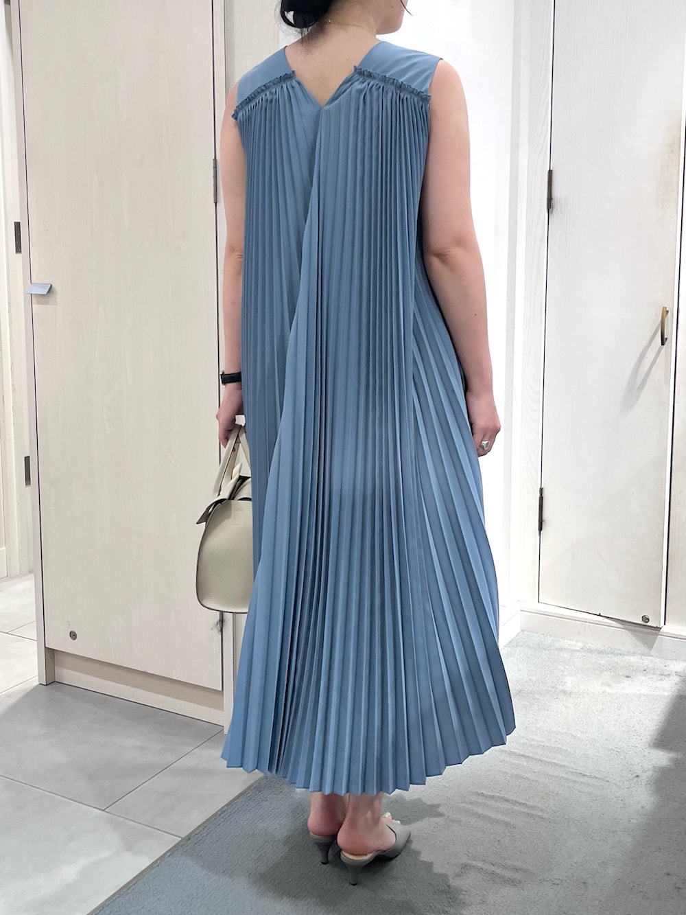 ブルー系のワンピース、ホワイト系のショルダーバッグ、シルバー系のネックレスを着用したレディースの夏コーディネートの4枚目の写真