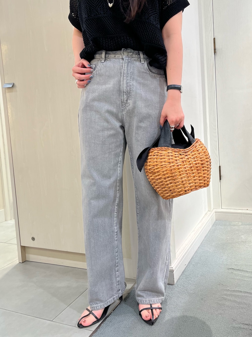 ブラック系のニット/セーター、ブラック系のデニムパンツ、ブラック系のトートバッグを着用したレディースの春コーディネートの6枚目の写真