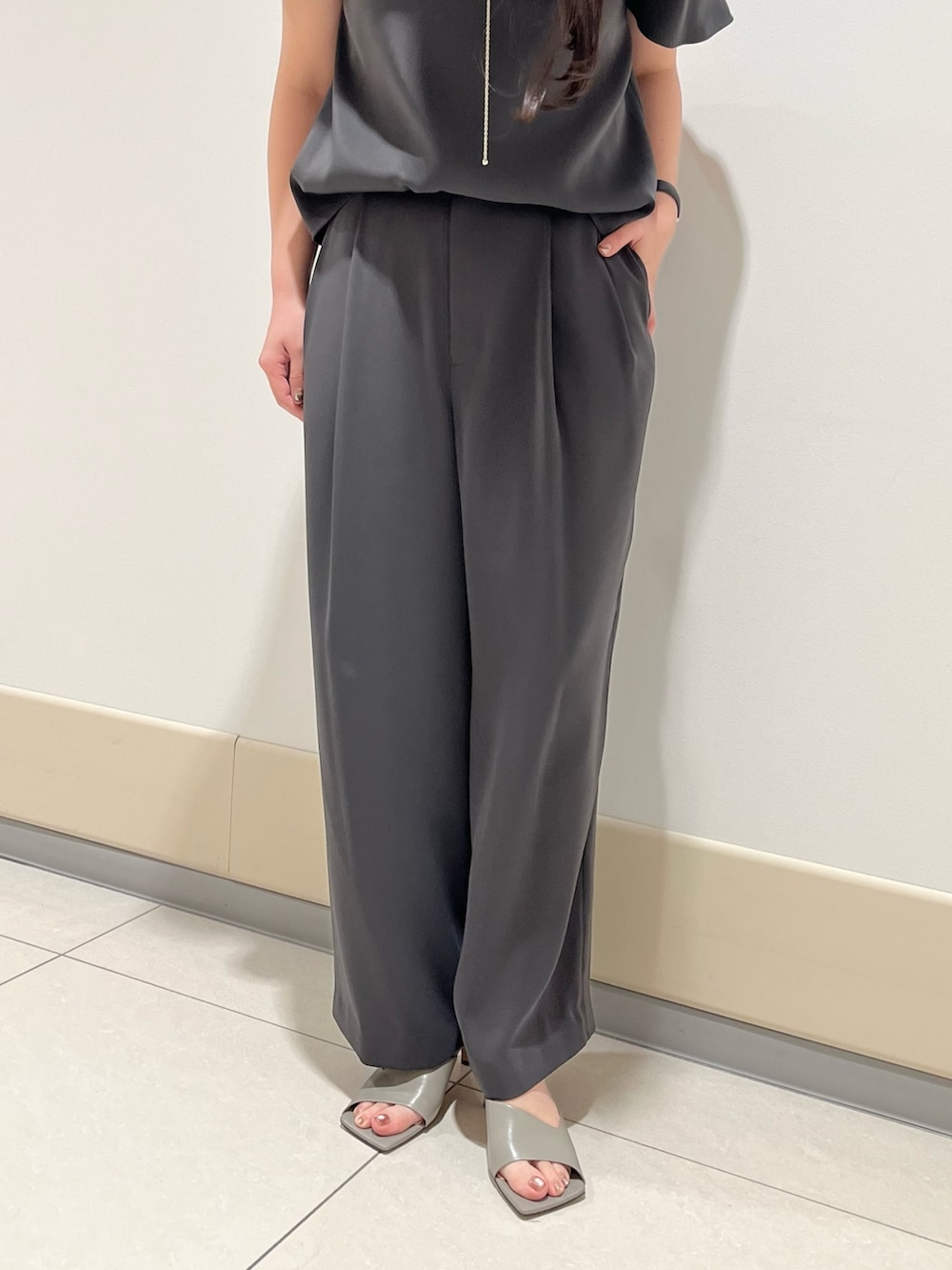 グレー系のシャツ/ブラウス、グレー系のスラックス、ブラック系のショルダーバッグを着用したレディースの春コーディネートの7枚目の写真