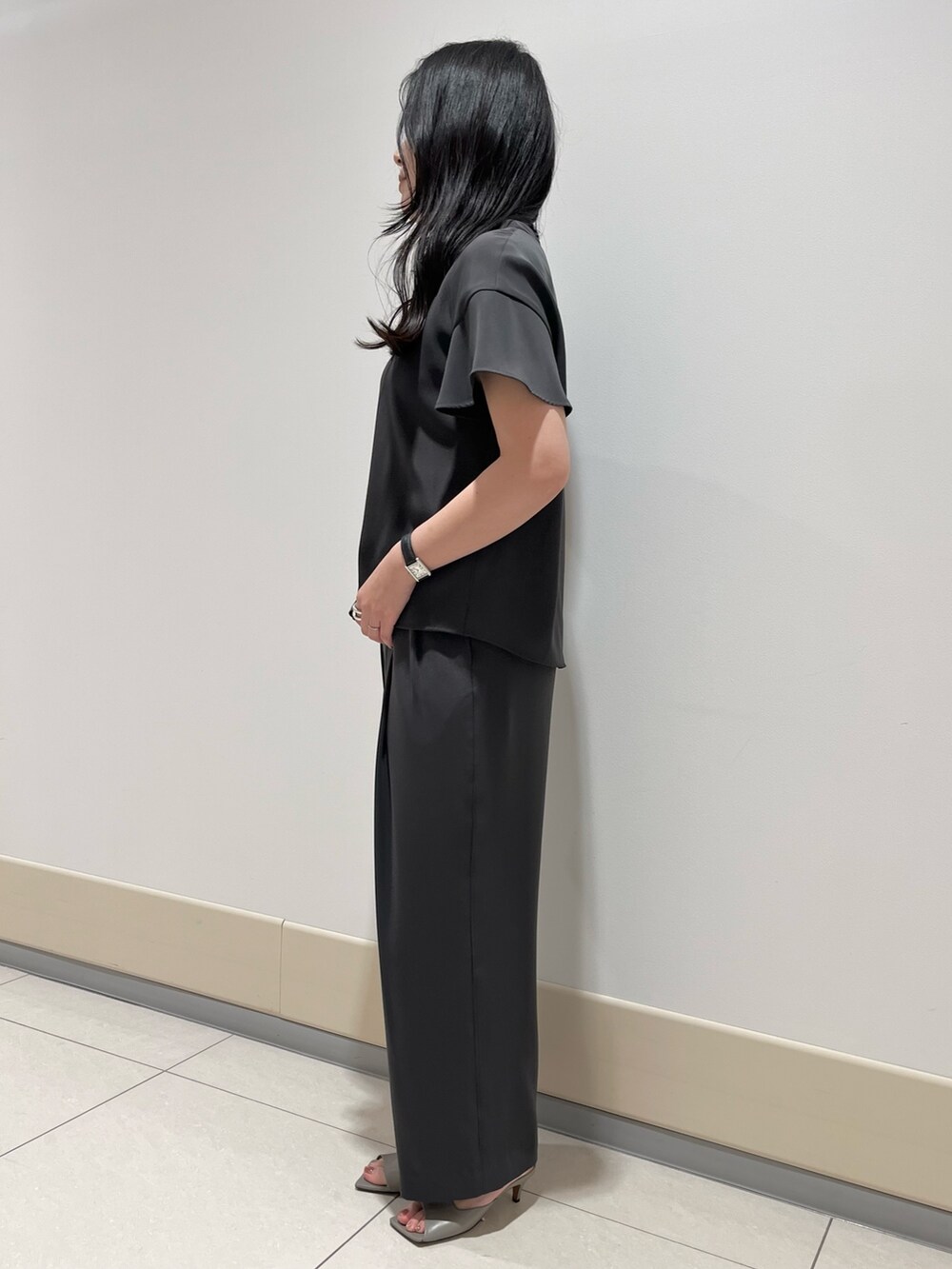 グレー系のシャツ/ブラウス、グレー系のスラックス、ブラック系のショルダーバッグを着用したレディースの春コーディネートの8枚目の写真