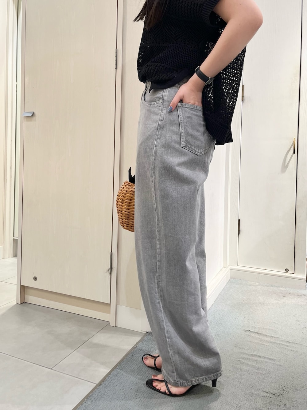 ブラック系のニット/セーター、ブラック系のデニムパンツ、ブラック系のトートバッグを着用したレディースの春コーディネートの7枚目の写真