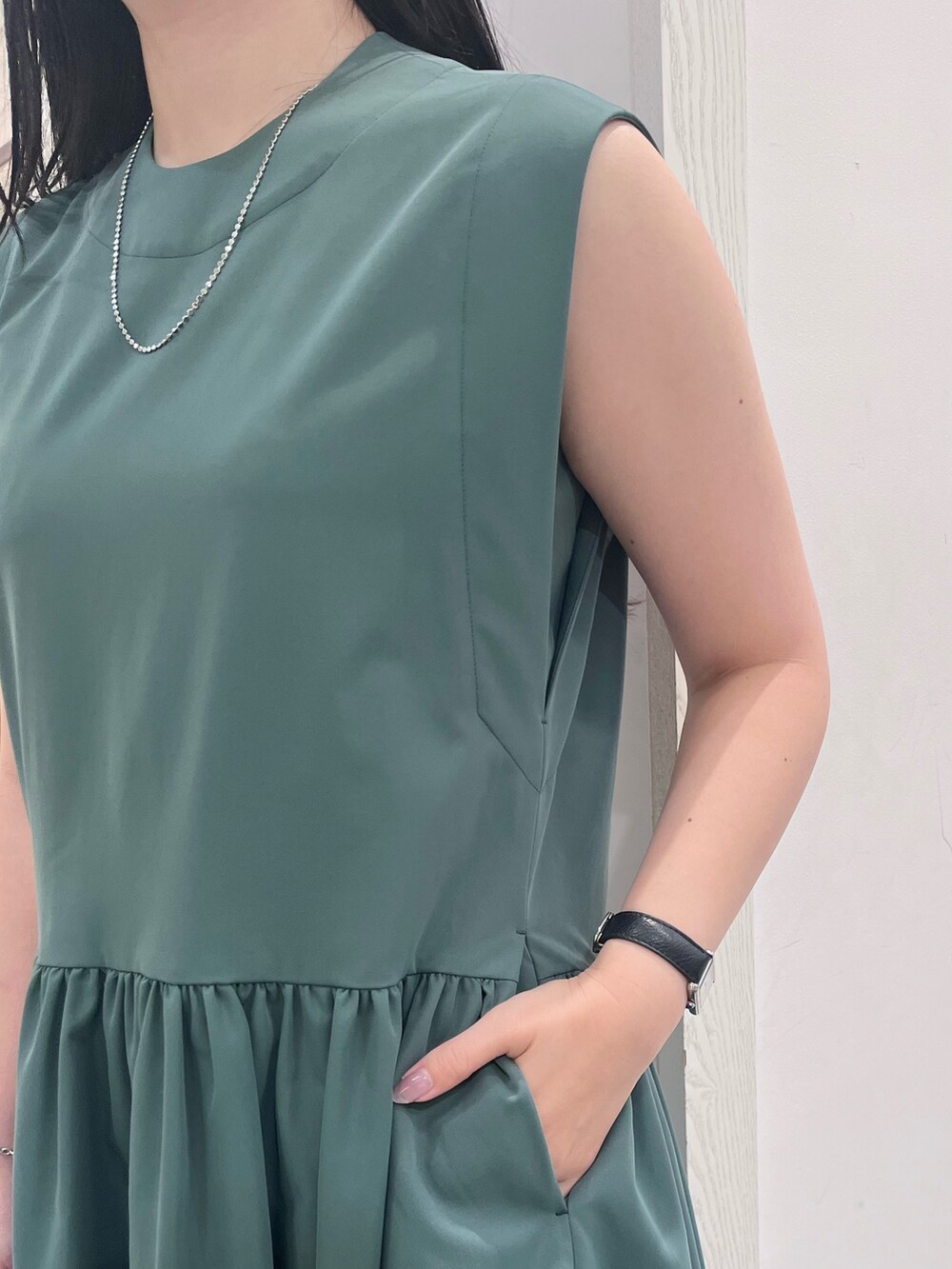 グリーン系のワンピース、ホワイト系のショルダーバッグ、シルバー系のネックレスを着用したレディースの夏コーディネートの4枚目の写真