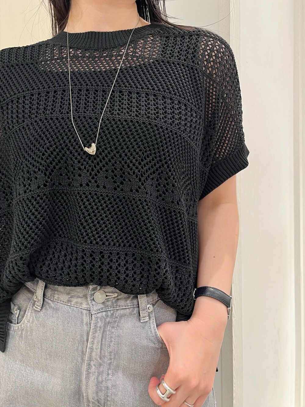 ブラック系のニット/セーター、ブラック系のデニムパンツ、ブラック系のトートバッグを着用したレディースの春コーディネートの8枚目の写真