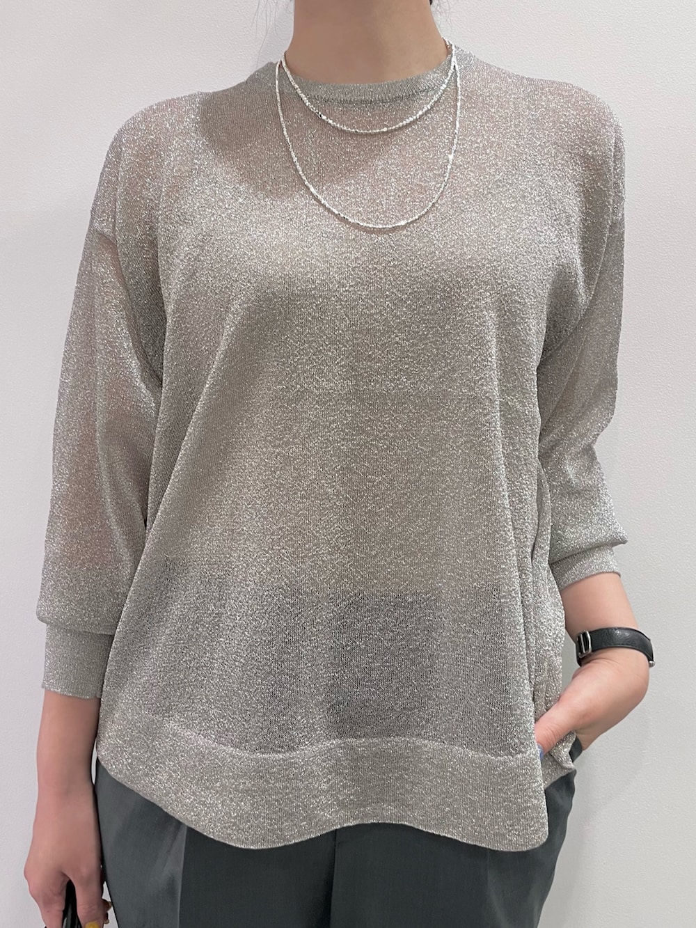 シルバー系のニット/セーター、グリーン系のスラックス、ブラック系のトートバッグを着用したレディースの夏コーディネートの3枚目の写真