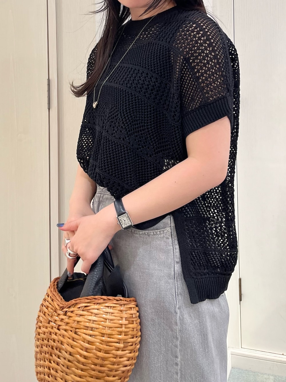 ブラック系のニット/セーター、ブラック系のデニムパンツ、ブラック系のトートバッグを着用したレディースの春コーディネートの3枚目の写真