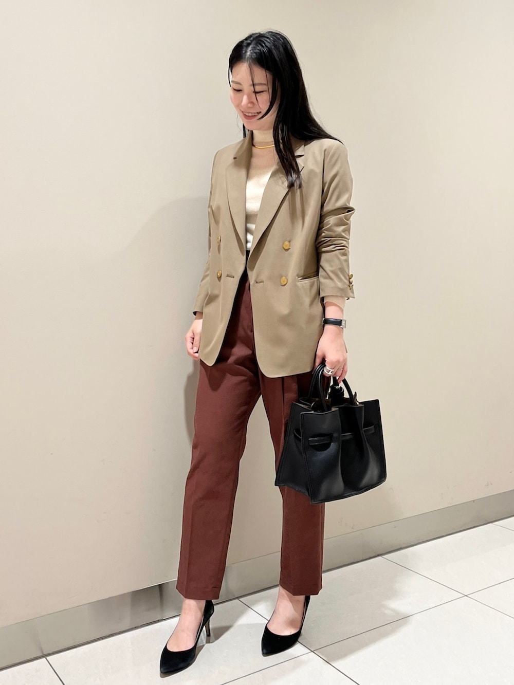 イエロー系のテーラードジャケット、ホワイト系のニット/セーター、レッド系のスラックスを着用したレディースの夏コーディネートの2枚目の写真