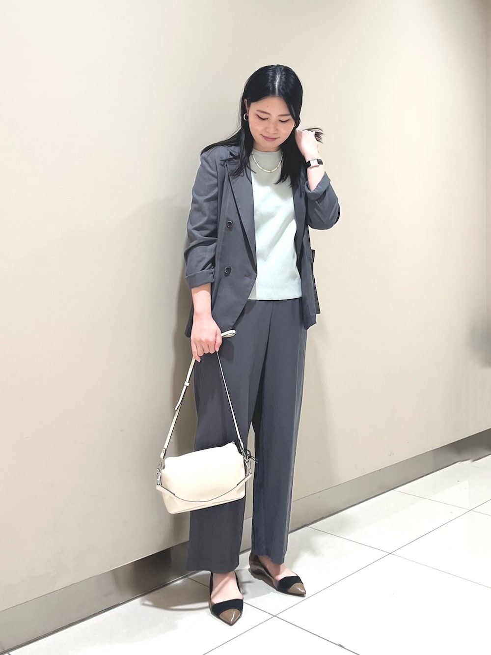 グレー系のその他パンツ、グリーン系のニット/セーター、グレー系のテーラードジャケットを着用したレディースの春コーディネートの2枚目の写真