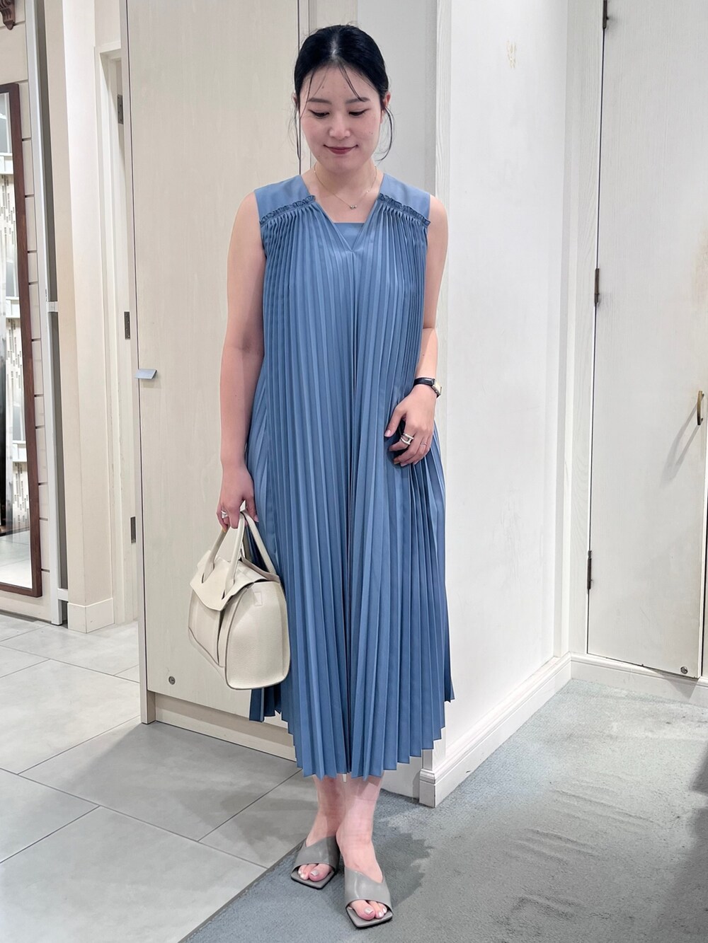 ブルー系のワンピース、ホワイト系のショルダーバッグ、シルバー系のネックレスを着用したレディースの夏コーディネートの2枚目の写真