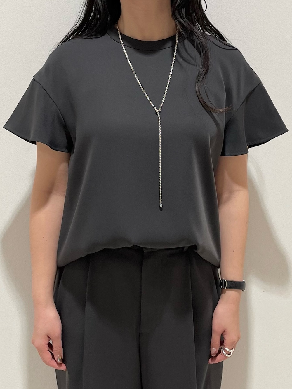 グレー系のシャツ/ブラウス、グレー系のスラックス、ブラック系のショルダーバッグを着用したレディースの春コーディネートの6枚目の写真