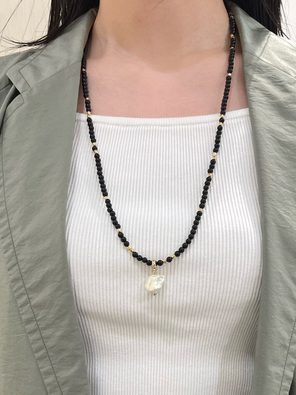 ホワイト系のタンクトップ、グリーン系のシャツ/ブラウス、ブラック系のその他パンツを着用したレディースの春コーディネートの9枚目の写真