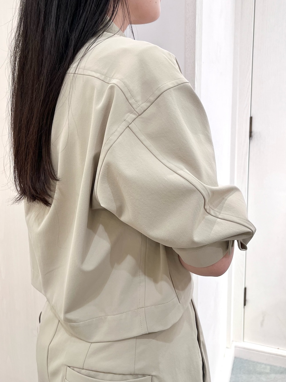 ベージュ系のブルゾン、ベージュ系のその他パンツ、ホワイト系のタンクトップを着用したレディースの春コーディネートの9枚目の写真