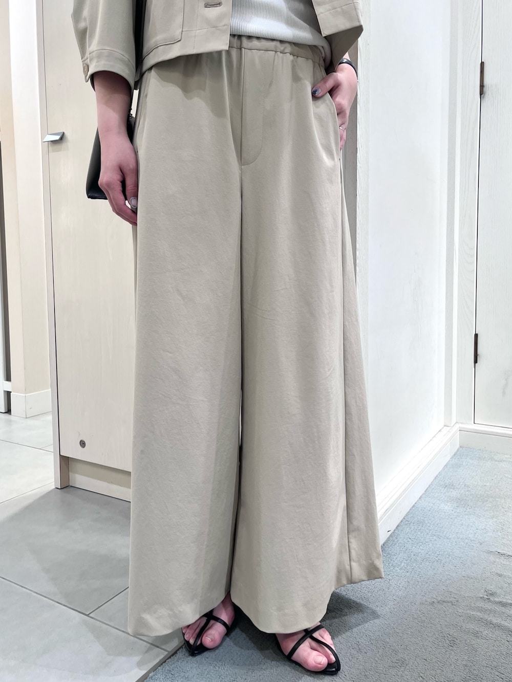 ベージュ系のブルゾン、ベージュ系のその他パンツ、ホワイト系のタンクトップを着用したレディースの春コーディネートの6枚目の写真