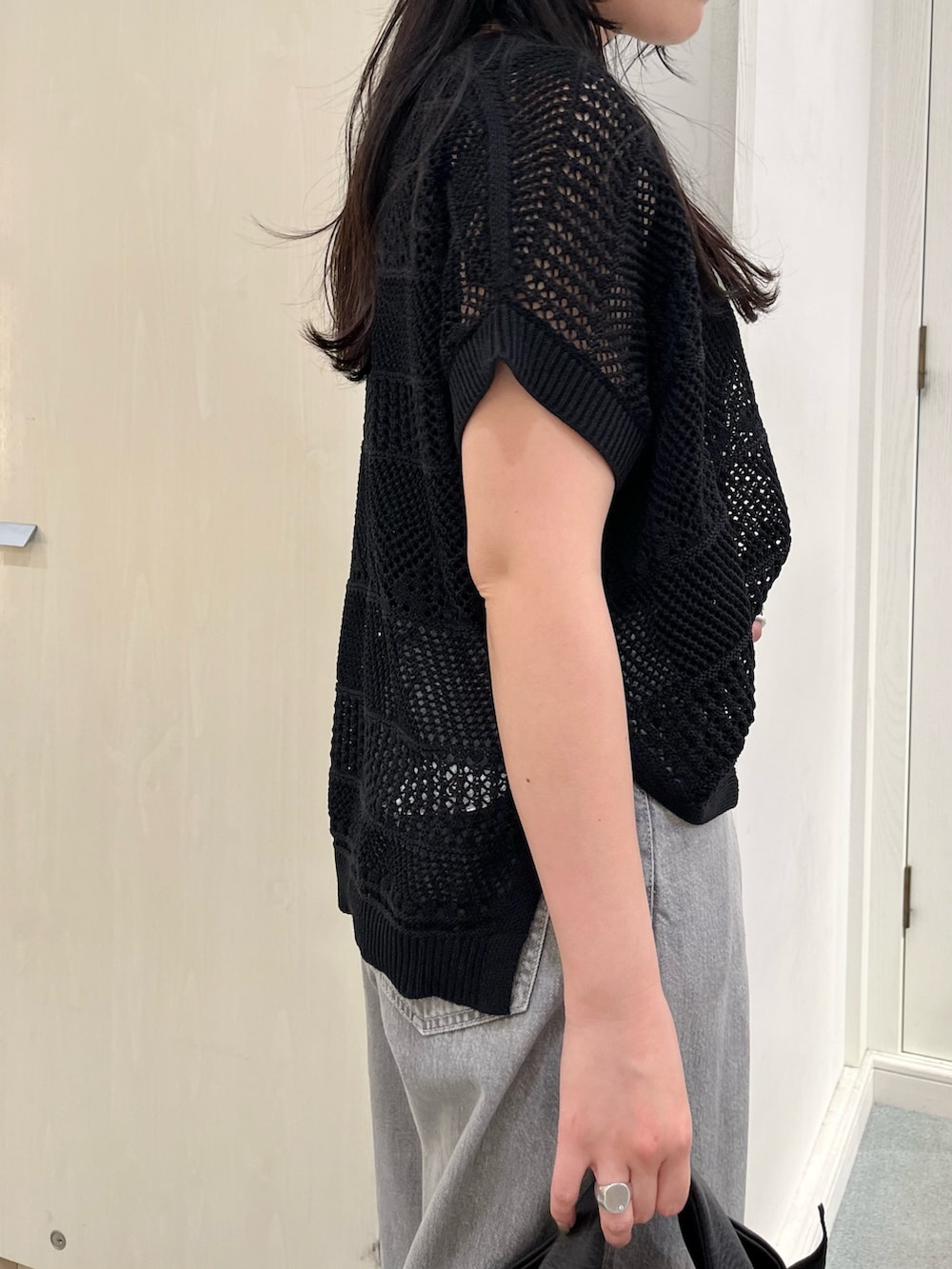 ブラック系のニット/セーター、ブラック系のデニムパンツ、ブラック系のトートバッグを着用したレディースの春コーディネートの4枚目の写真