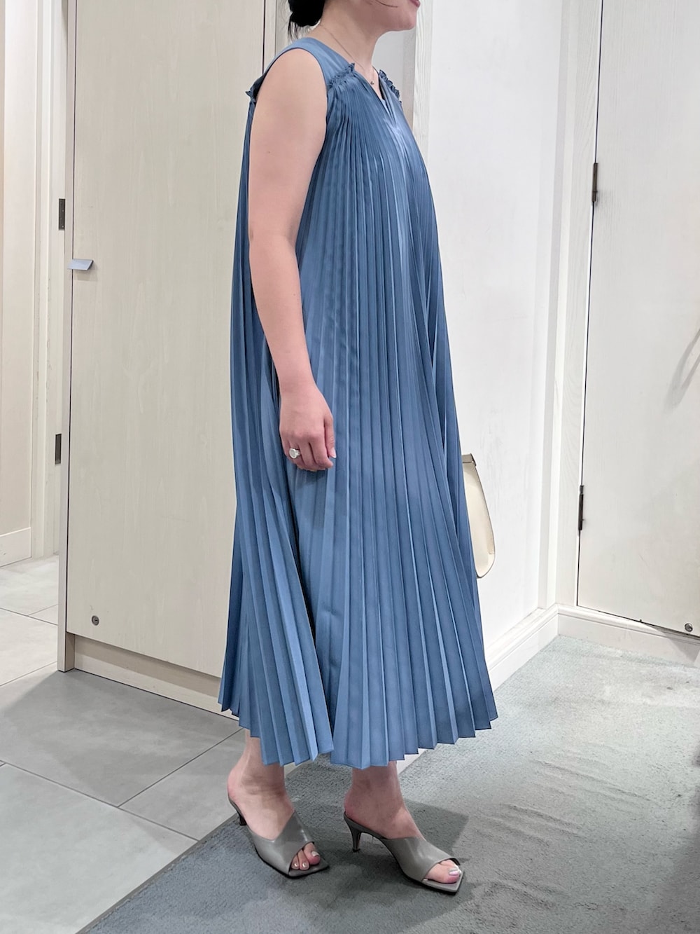 ブルー系のワンピース、ホワイト系のショルダーバッグ、シルバー系のネックレスを着用したレディースの夏コーディネートの5枚目の写真