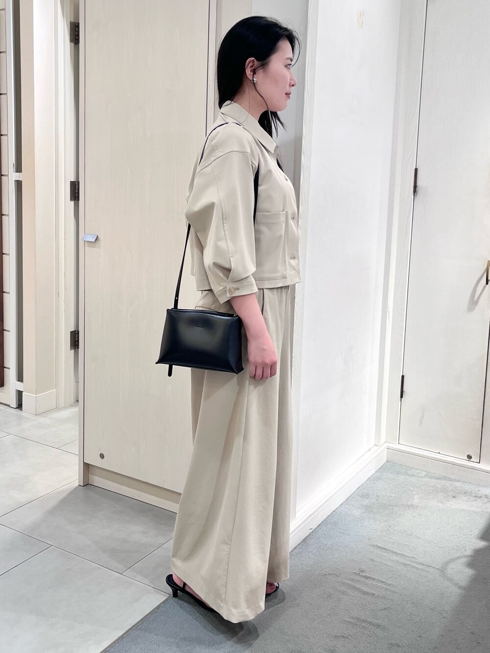 ベージュ系のブルゾン、ベージュ系のその他パンツ、ホワイト系のタンクトップを着用したレディースの春コーディネートの5枚目の写真