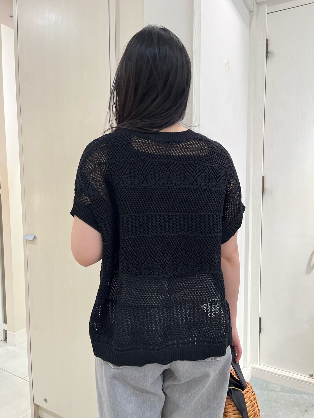 ブラック系のニット/セーター、ブラック系のデニムパンツ、ブラック系のトートバッグを着用したレディースの春コーディネートの5枚目の写真