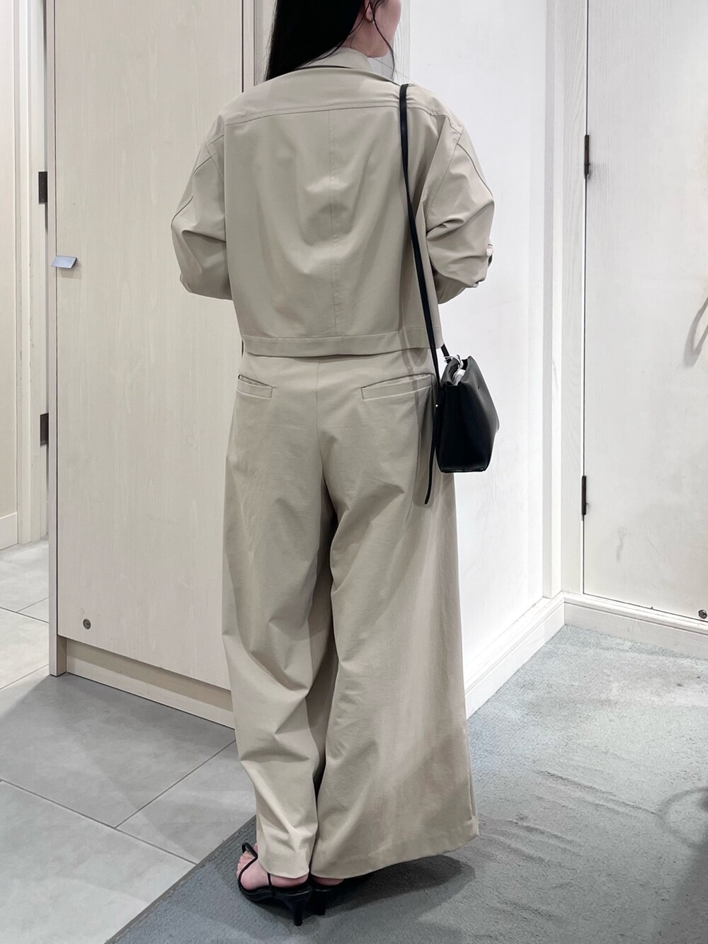 ベージュ系のブルゾン、ベージュ系のその他パンツ、ホワイト系のタンクトップを着用したレディースの春コーディネートの4枚目の写真