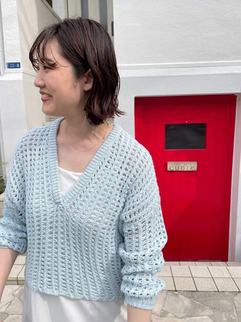 ベージュ系のサンダル、ホワイト系のワンピース、ブルー系のニット/セーターを着用したレディースの夏コーディネートの4枚目の写真