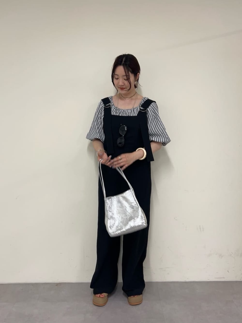 ブラック系のサロペット/オーバーオール、ブラック系のシャツ/ブラウス、ベージュ系のサンダルを着用したレディースの夏コーディネートの2枚目の写真