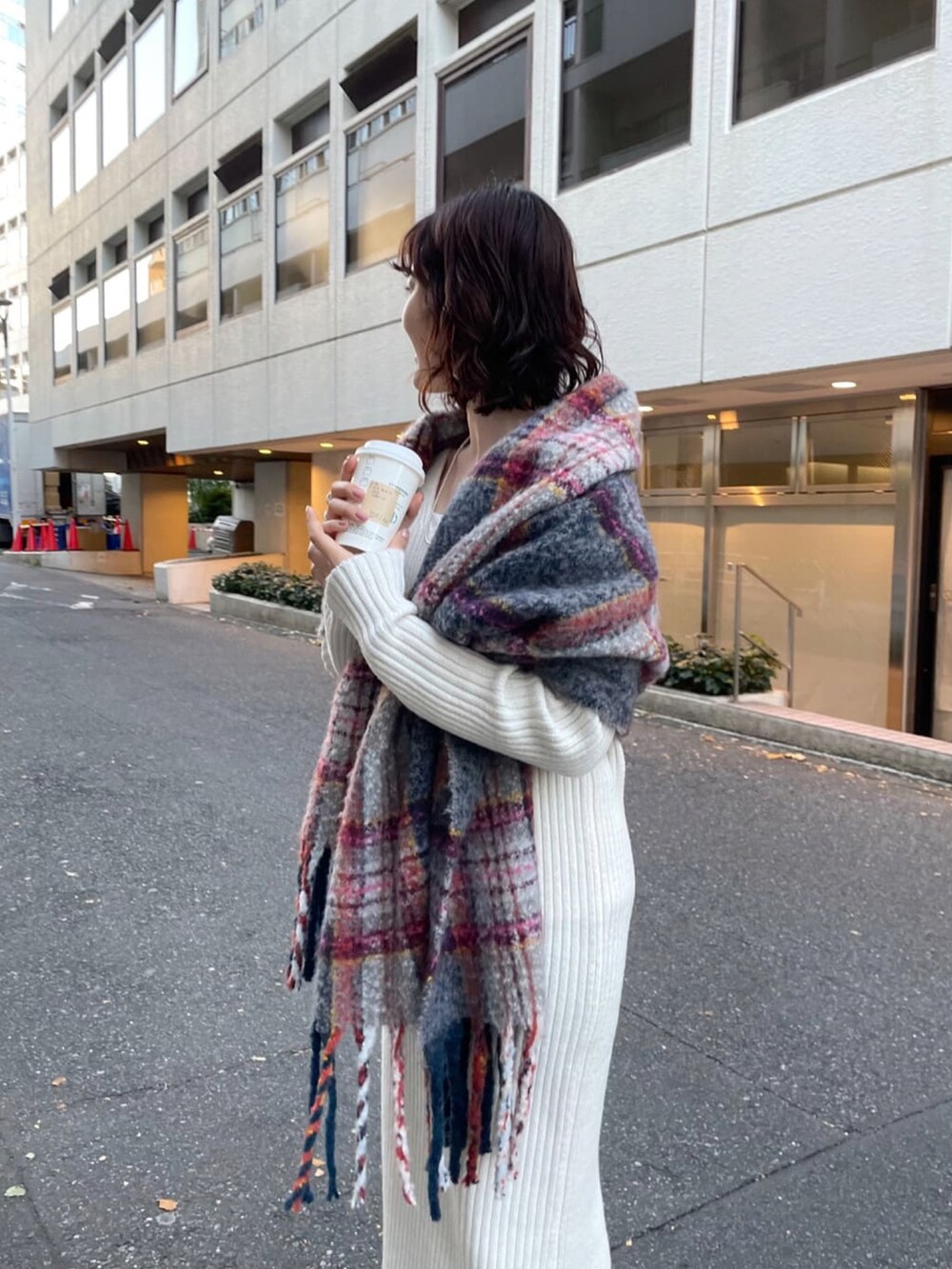 ブラック系のブーツ、ホワイト系のワンピース、グレー系のストール/ショールを着用したレディースの冬コーディネートの4枚目の写真