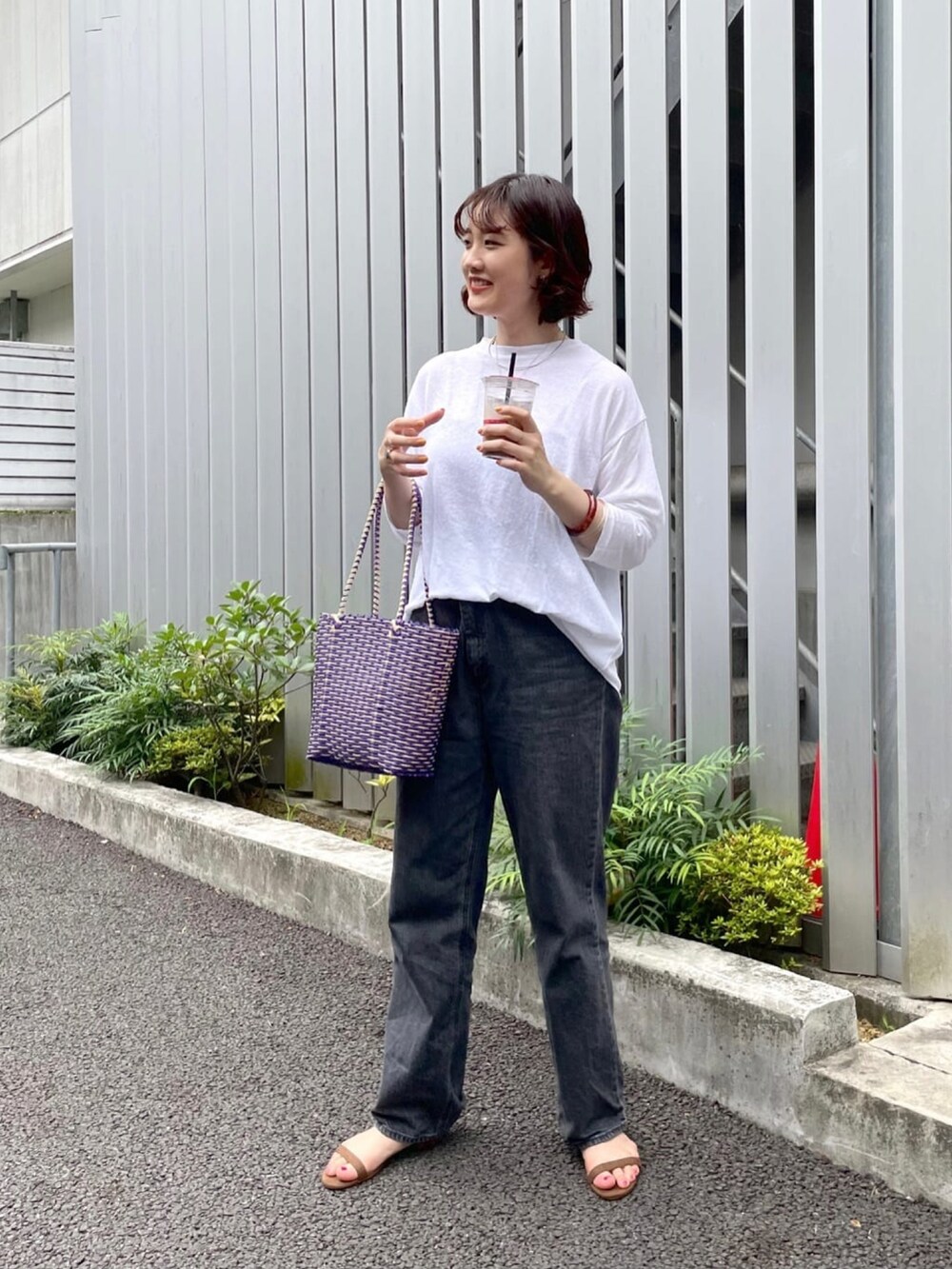 ブラック系のデニムパンツ、ホワイト系のTシャツ/カットソー、ブラック系のキャミソールを着用したレディースの夏コーディネートの2枚目の写真