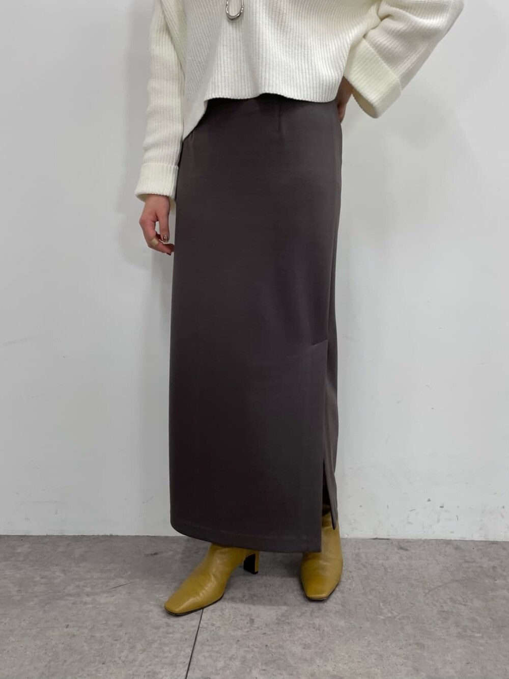 ブルー系のニット/セーター、ホワイト系のキャミソール、ブラック系のスカートを着用したレディースの冬コーディネートの3枚目の写真