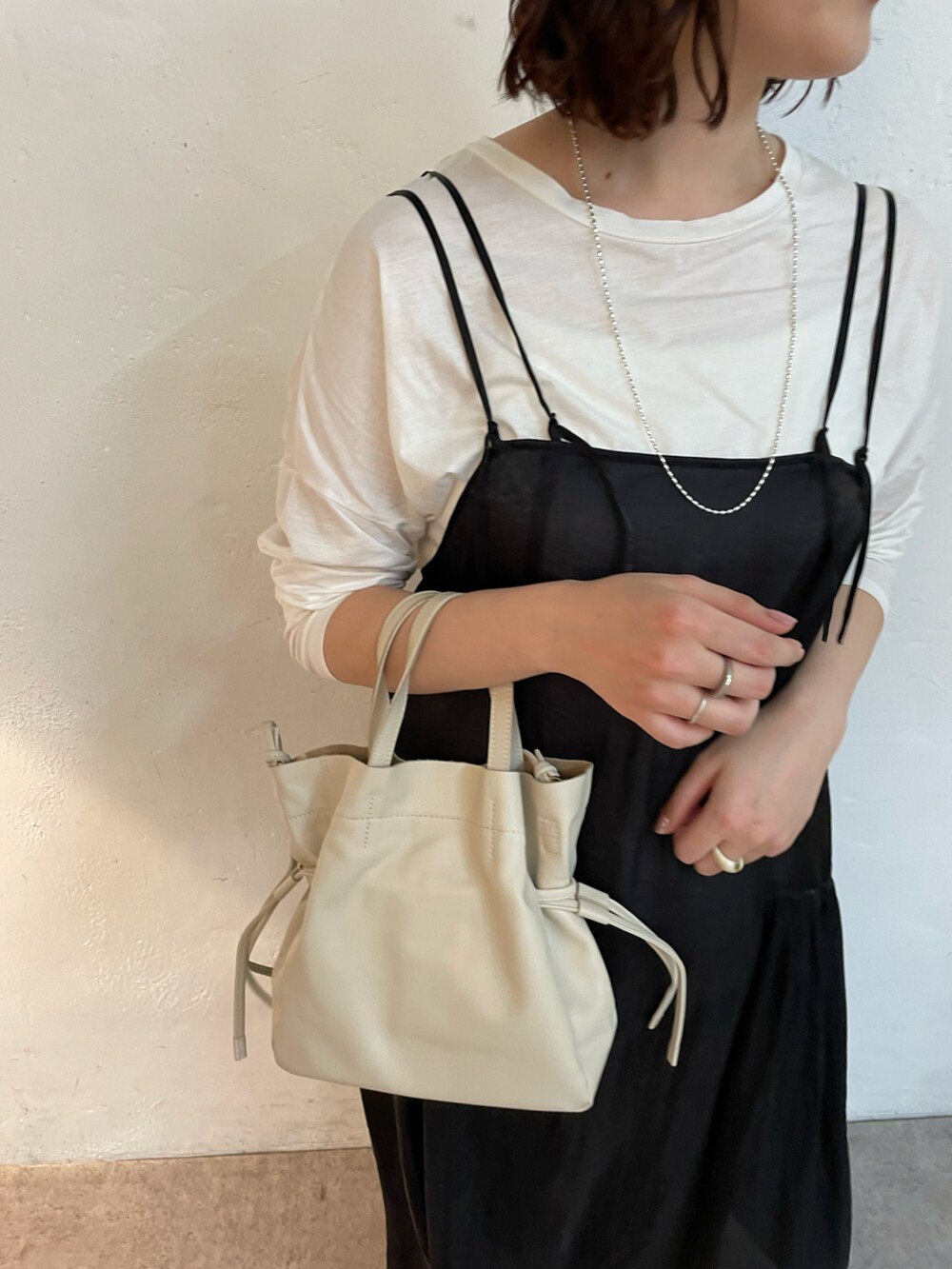 ブラック系のバレエシューズ、ブラック系のワンピース、ホワイト系のTシャツ/カットソーを着用したレディースの冬コーディネートの4枚目の写真