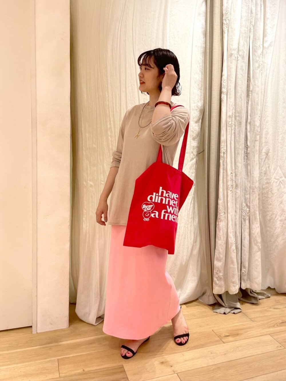 ベージュ系のTシャツ/カットソー、ブラック系のスカート、ベージュ系のサンダルを着用したレディースの夏コーディネートの3枚目の写真