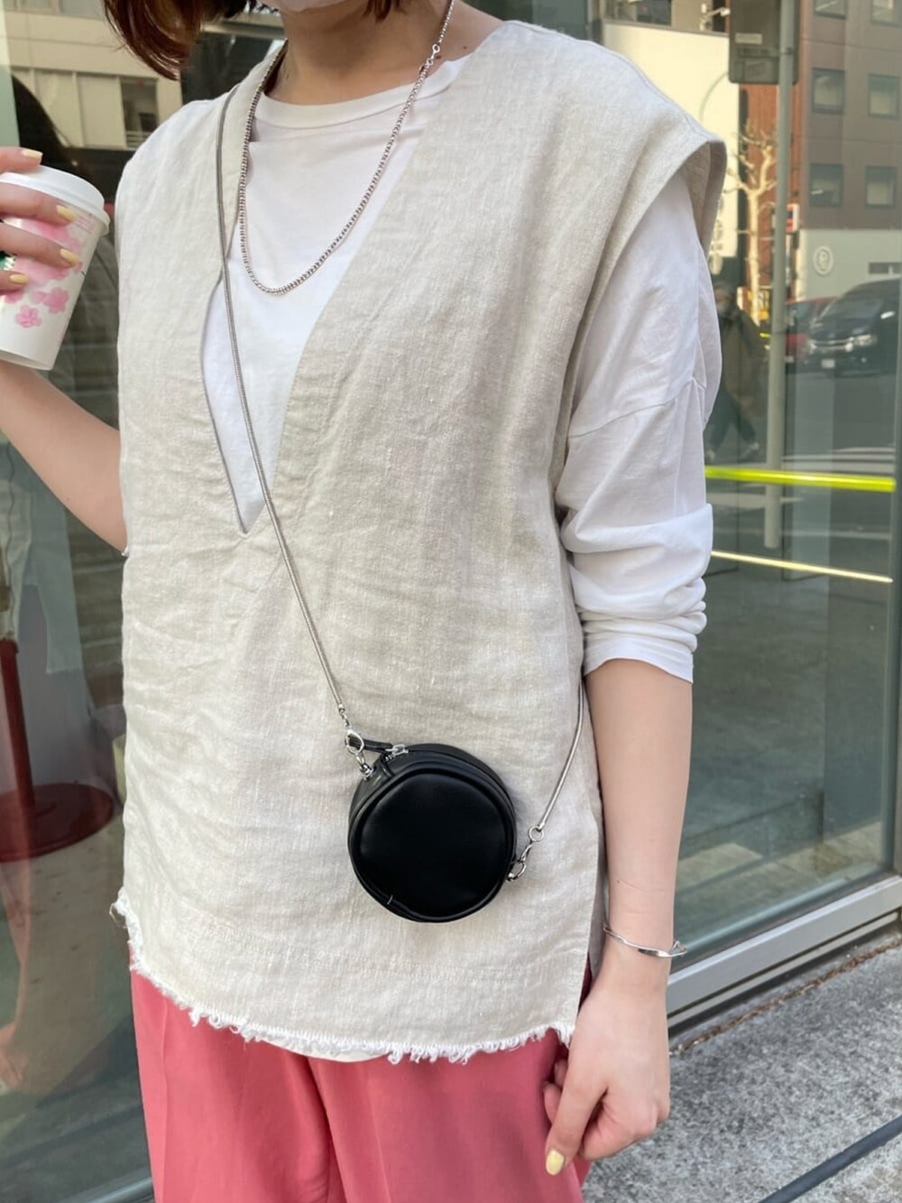 ホワイト系のTシャツ/カットソー、ブルー系のショルダーバッグ、ベージュ系のスニーカーを着用したレディースの春コーディネートの4枚目の写真