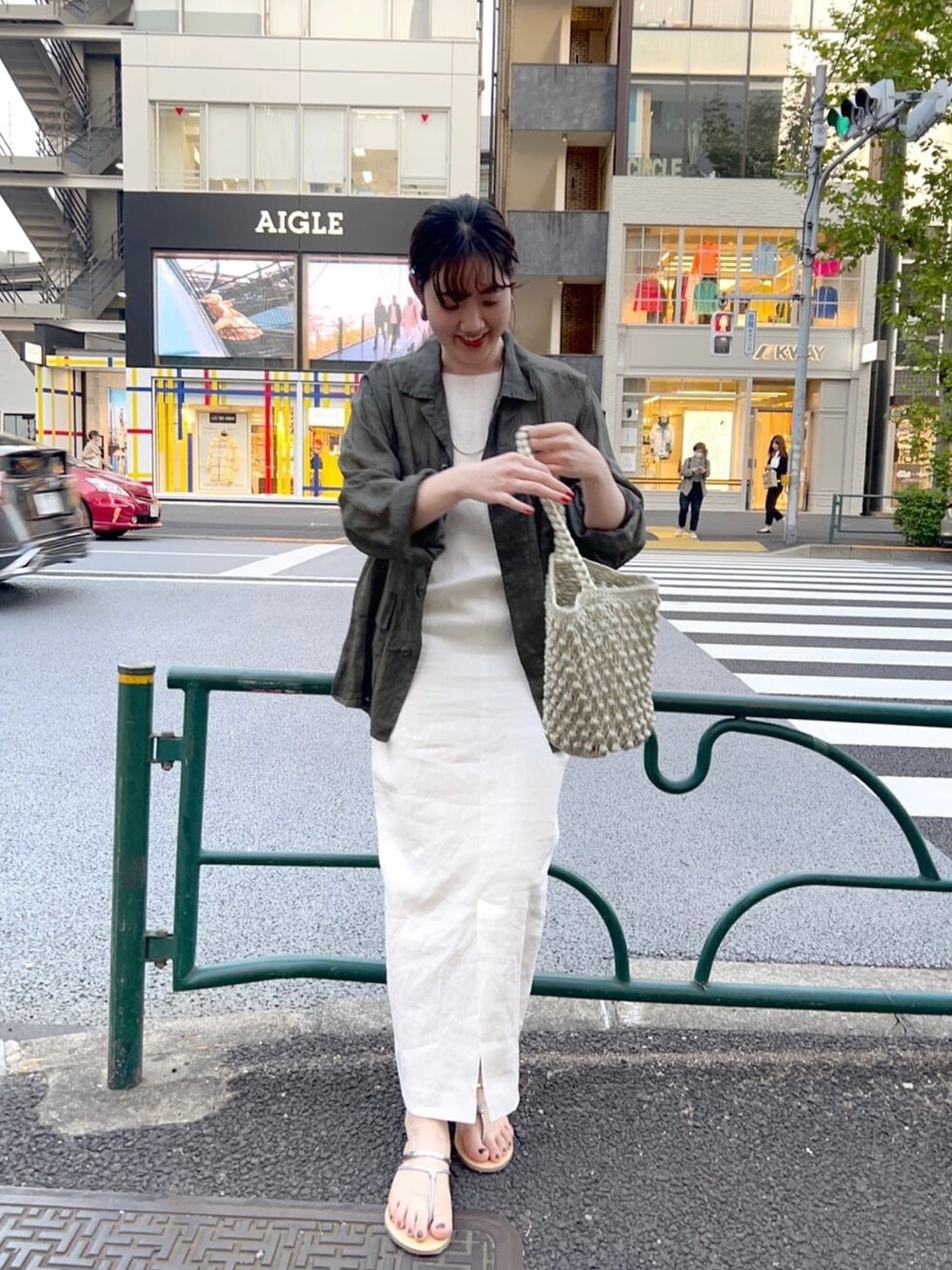 グリーン系のジャケット/アウター、ホワイト系のワンピース、ゴールド系のサンダルを着用したレディースの春コーディネートの3枚目の写真