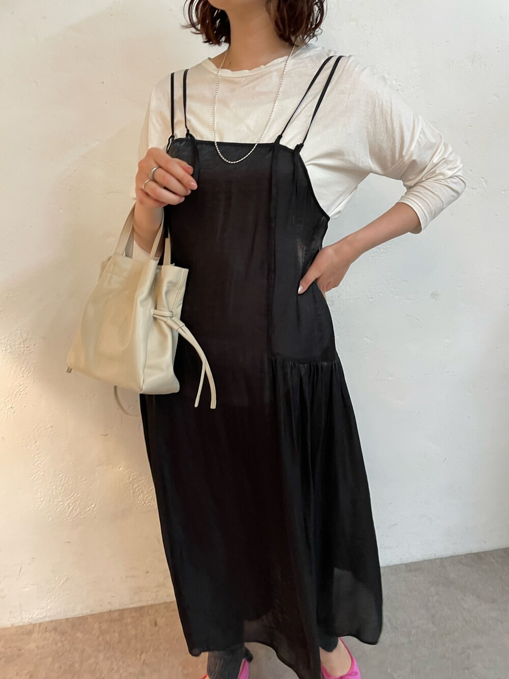 ブラック系のバレエシューズ、ブラック系のワンピース、ホワイト系のTシャツ/カットソーを着用したレディースの冬コーディネートの3枚目の写真