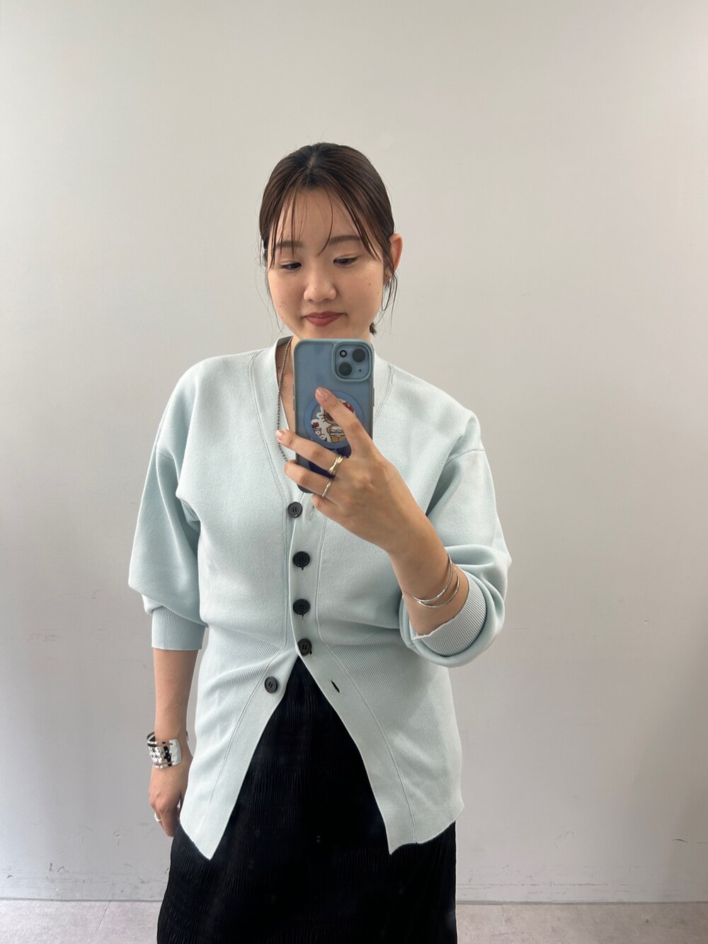 ブルー系のカーディガン/ボレロ、ブラック系のスカートを着用したレディースの夏コーディネートの2枚目の写真