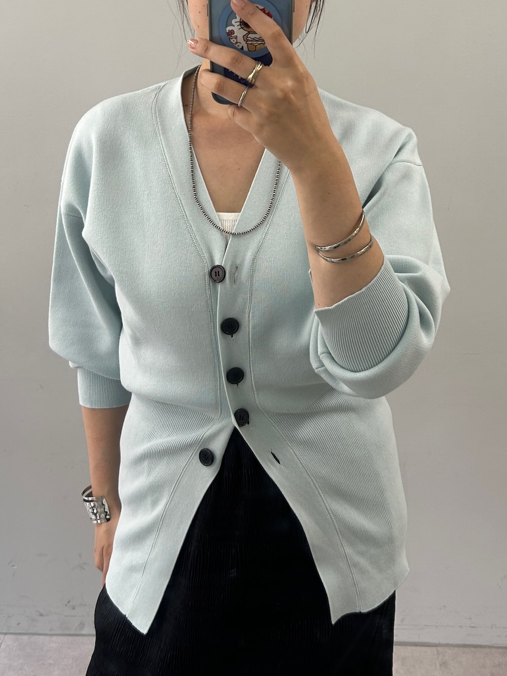 ブルー系のカーディガン/ボレロ、ブラック系のスカートを着用したレディースの夏コーディネートの3枚目の写真