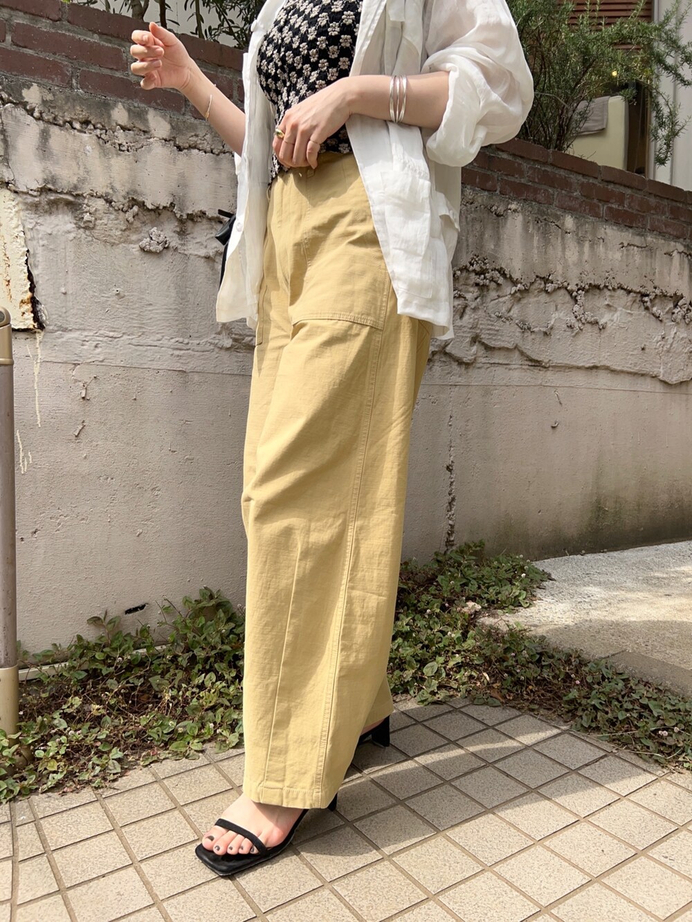 グリーン系のジャケット/アウター、ブラック系のTシャツ/カットソー、ベージュ系のパンツを着用したレディースの春コーディネートの5枚目の写真