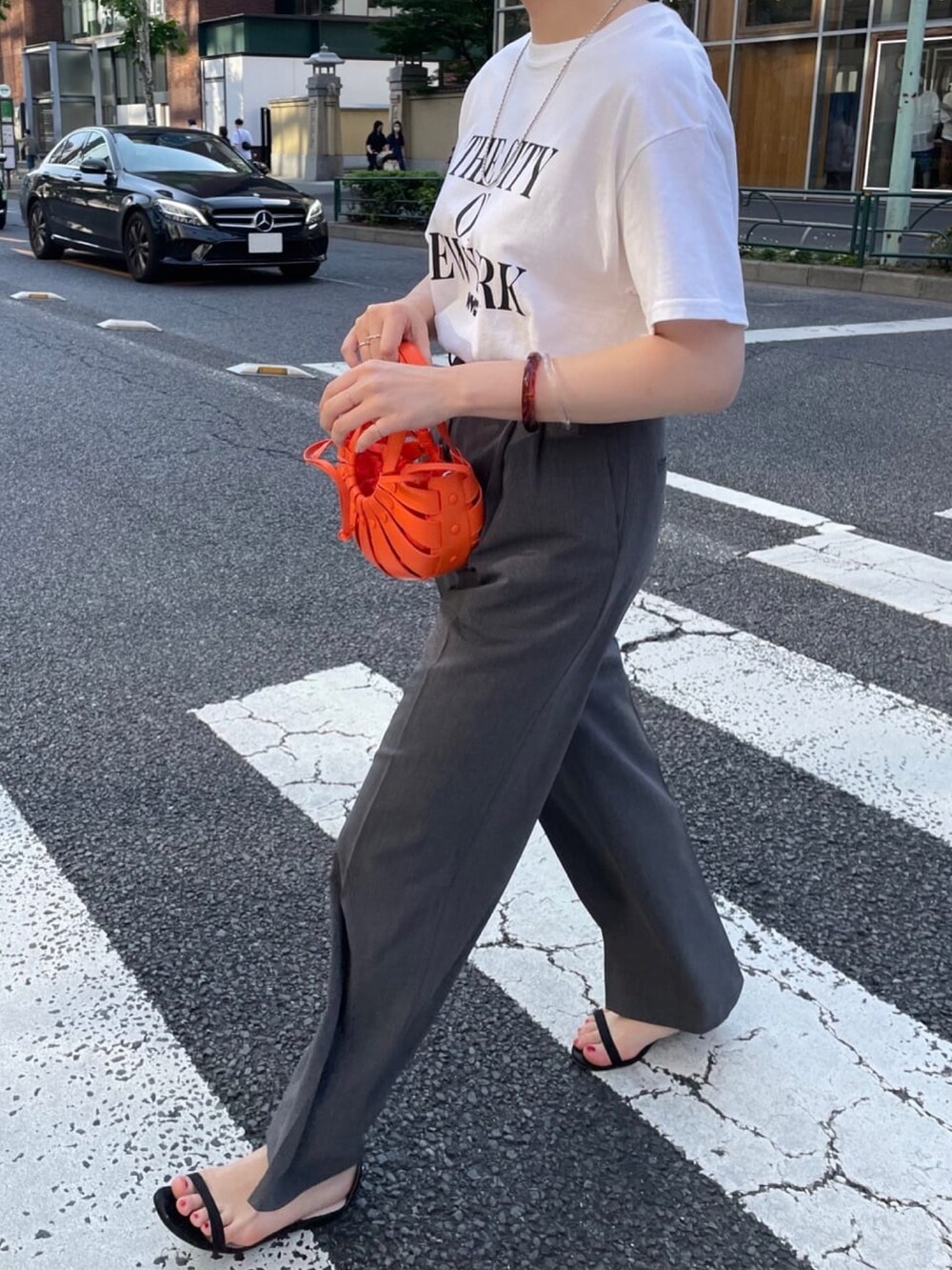 グレー系のその他パンツ、ベージュ系のサンダル、ホワイト系のTシャツ/カットソーを着用したレディースの夏コーディネートの3枚目の写真