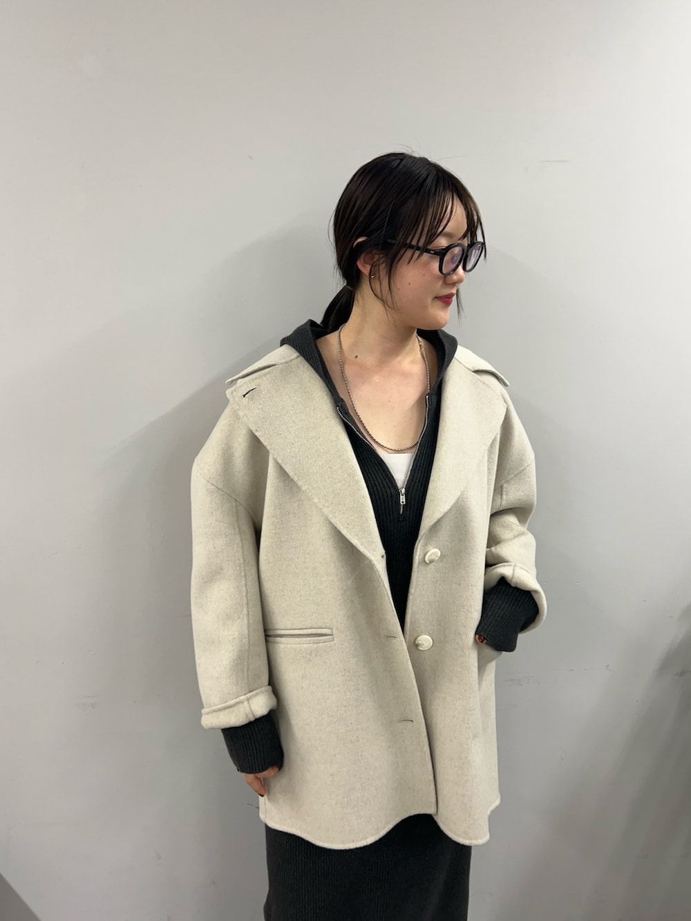 グレー系のワンピース、ブラック系のブーツ、ホワイト系のその他アウターを着用したレディースの秋コーディネートの3枚目の写真