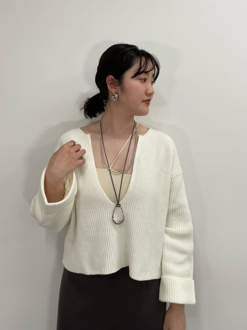 ブルー系のニット/セーター、ホワイト系のキャミソール、ブラック系のスカートを着用したレディースの冬コーディネートの2枚目の写真