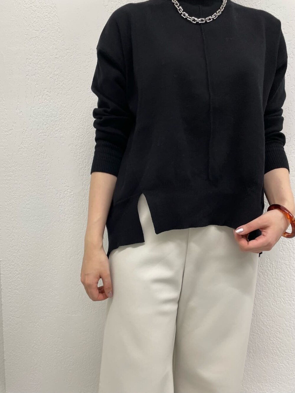 グレー系のその他パンツ、ブラック系のニット/セーター、シルバー系のネックレスを着用したレディースの冬コーディネートの4枚目の写真