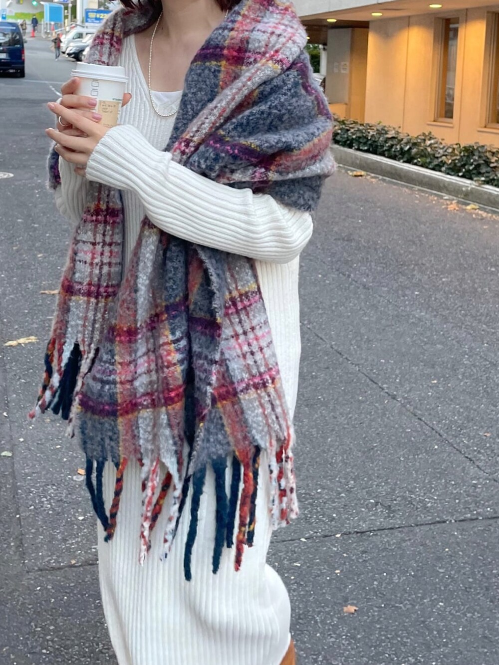 ブラック系のブーツ、ホワイト系のワンピース、グレー系のストール/ショールを着用したレディースの冬コーディネートの2枚目の写真