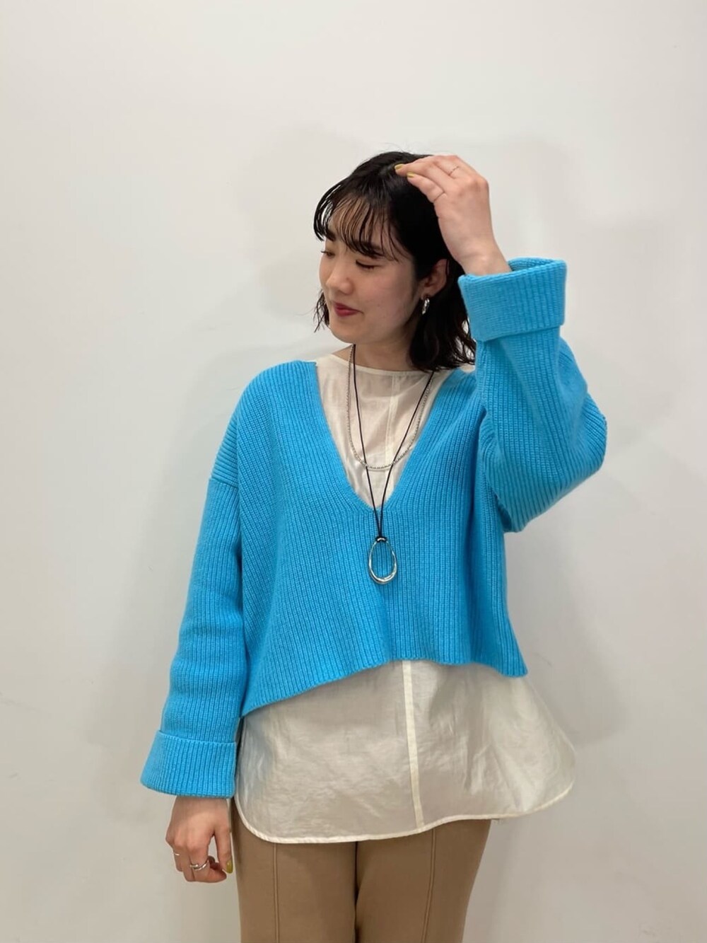 ブルー系のニット/セーター、ホワイト系のシャツ/ブラウス、ブラウン系のその他パンツを着用したレディースの冬コーディネートの3枚目の写真