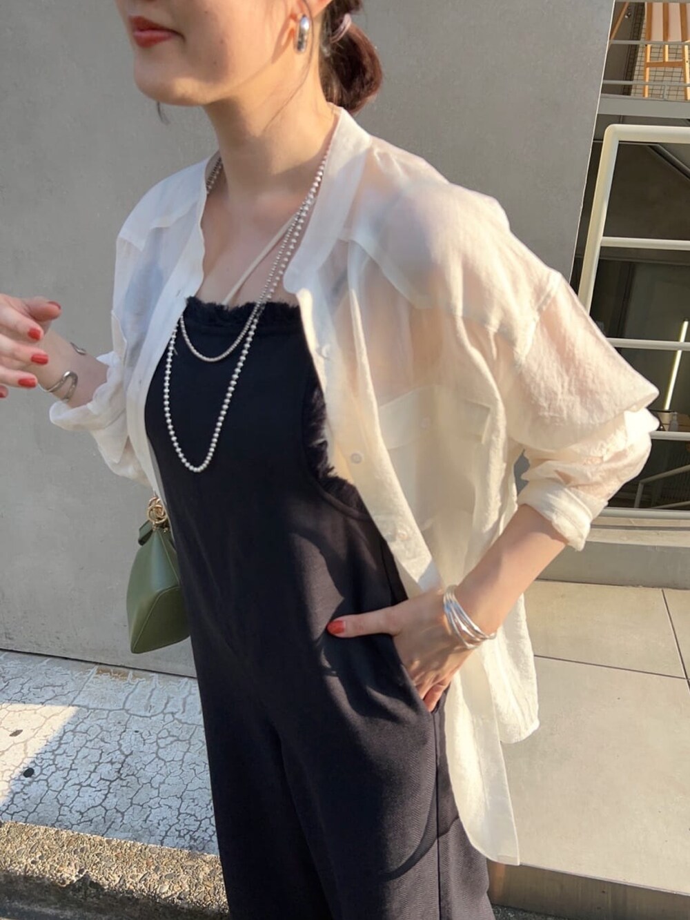 ホワイト系のシャツ/ブラウス、グレー系のサロペット/オーバーオール、ブラック系のハンドバッグを着用したレディースの春コーディネートの5枚目の写真