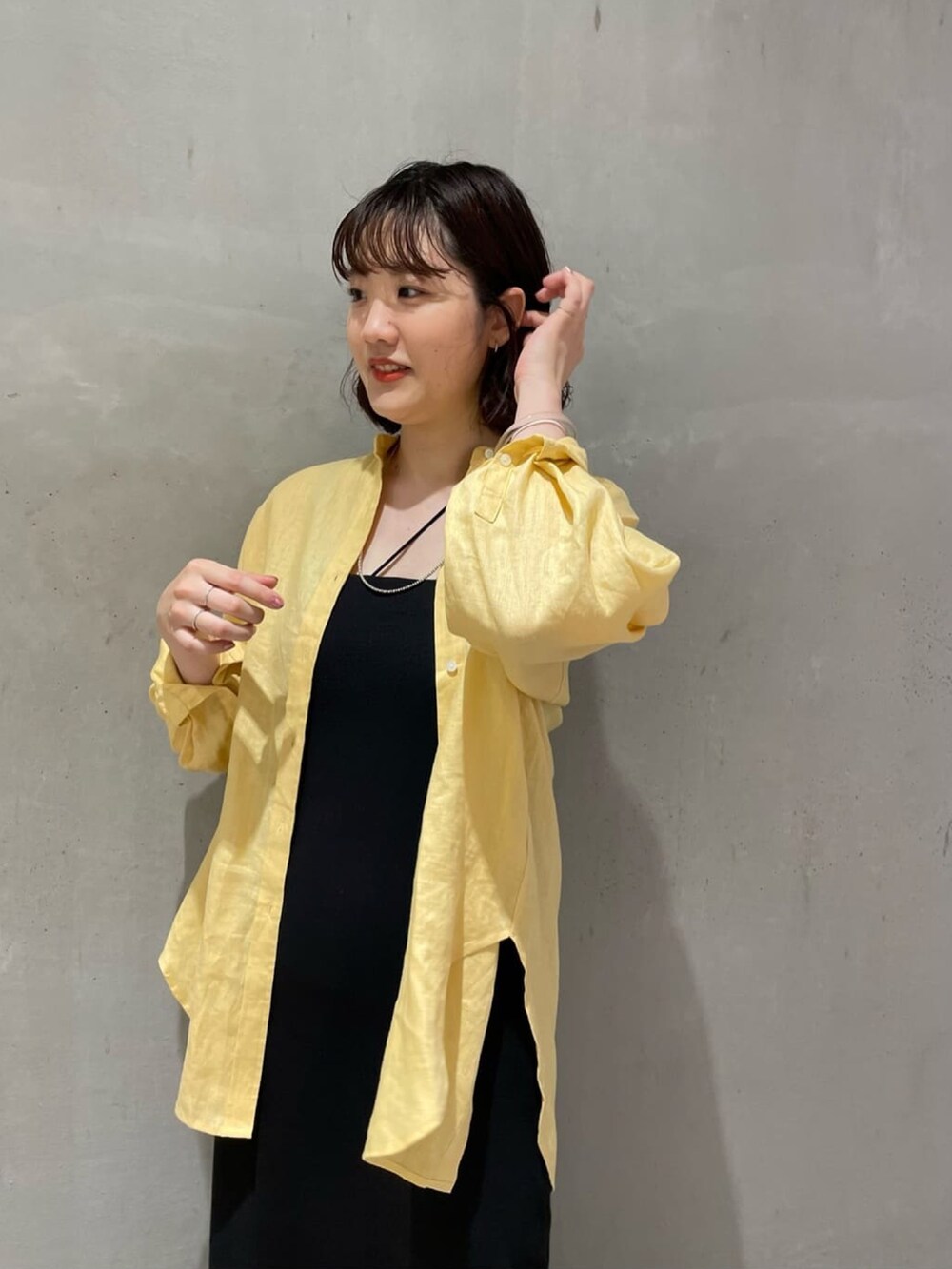 イエロー系のシャツ/ブラウス、ブラック系のワンピース、ブラック系のキャミソールを着用したレディースの夏コーディネートの3枚目の写真