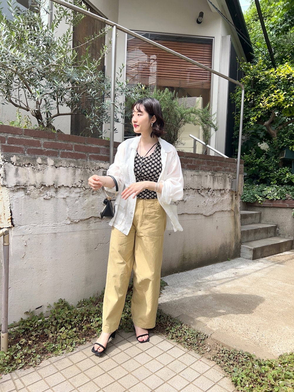 グリーン系のジャケット/アウター、ブラック系のTシャツ/カットソー、ベージュ系のパンツを着用したレディースの春コーディネートの2枚目の写真