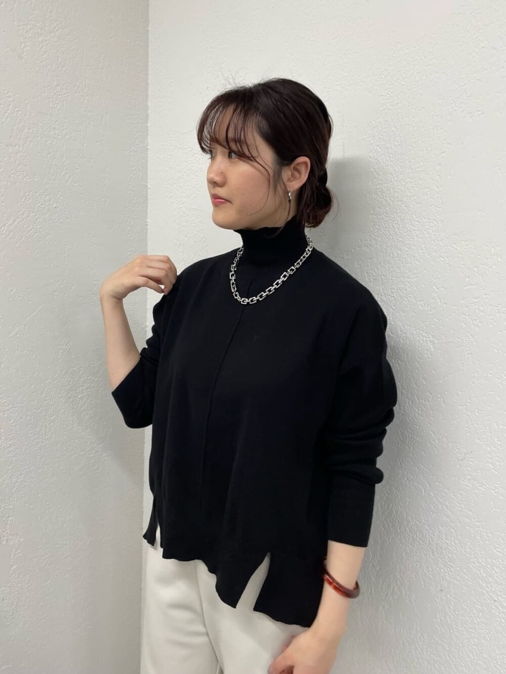 グレー系のその他パンツ、ブラック系のニット/セーター、シルバー系のネックレスを着用したレディースの冬コーディネートの3枚目の写真