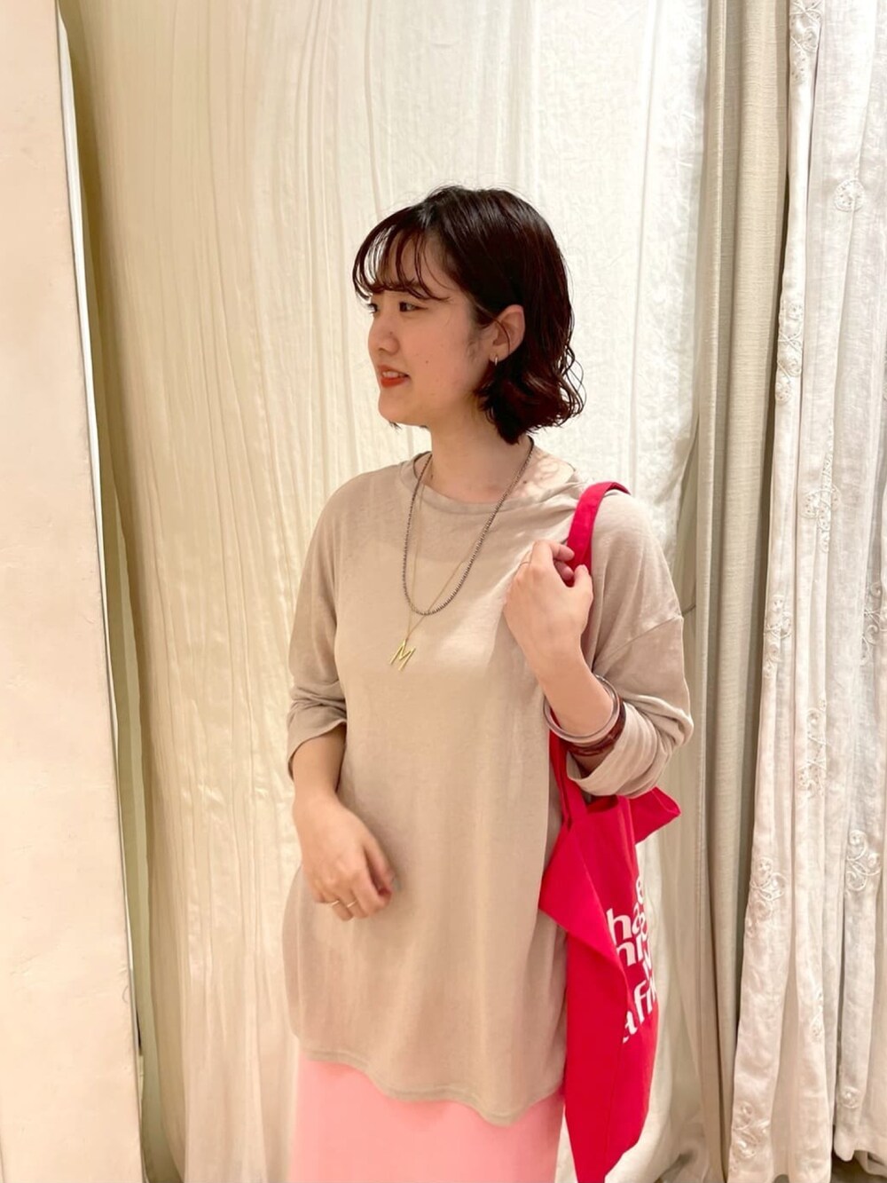 ベージュ系のTシャツ/カットソー、ブラック系のスカート、ベージュ系のサンダルを着用したレディースの夏コーディネートの4枚目の写真