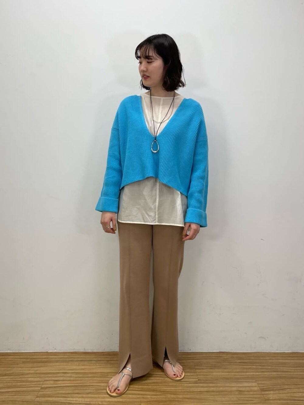ブルー系のニット/セーター、ホワイト系のシャツ/ブラウス、ブラウン系のその他パンツを着用したレディースの冬コーディネートの2枚目の写真